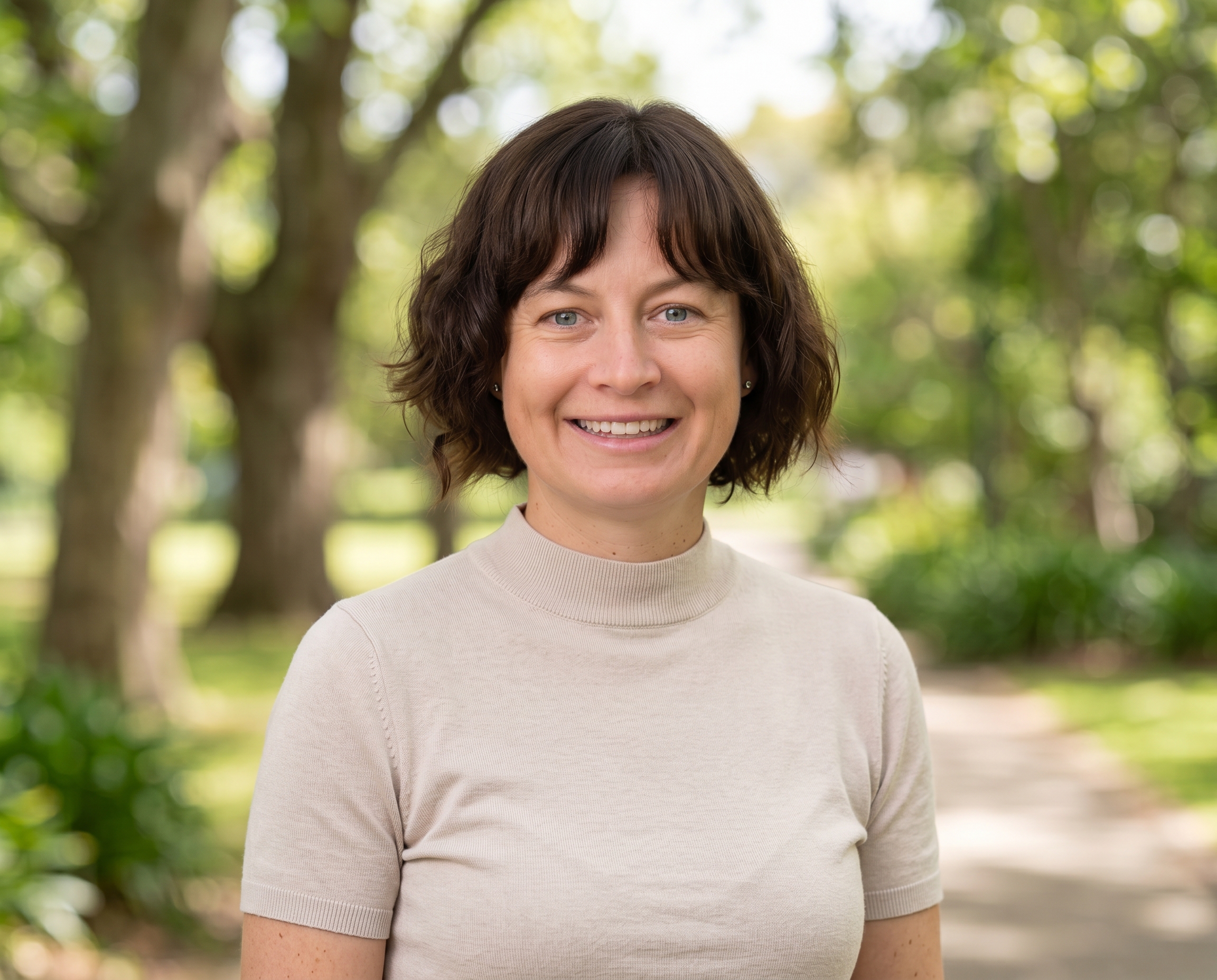 Portrait of Emily Jenkins, SALT° Co-Founder, against a bright outdoor green bokeh background.